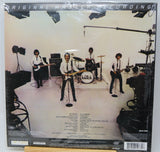 The back cover of a Knockout vinyl record sleeve, showing the original master recording studio scene with the band members performing. The cover features a white background with a black border, track listings, and a barcode at the bottom.