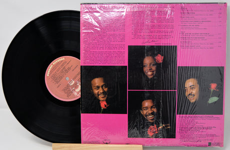Vinyl record with a pink cover featuring black and white portraits and text.