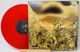Back cover of Korn's Follow the Leader album next to red vinyl record
