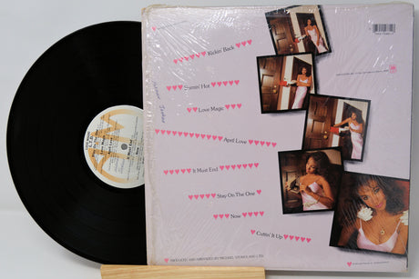 Vinyl record with a cover featuring multiple photos of a woman on a light gray background