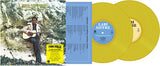 Yellow vinyl records with a person playing guitar on the cover, set against a mountainous background.