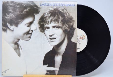 Vinyl record with cover featuring two people and 'Larsen Feiten Band' text on a light blue background