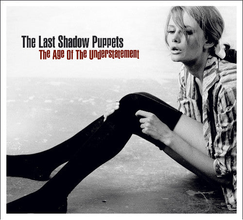 Album cover for 'The Age of the Understatement' by The Last Shadow Puppets featuring a gorgeous woman with long legs and stockings sitting on the ground.