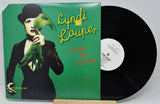 Vinyl record with a green cover featuring a person holding leaves, and the title 'Come on Home' by Cyndi Lauper.