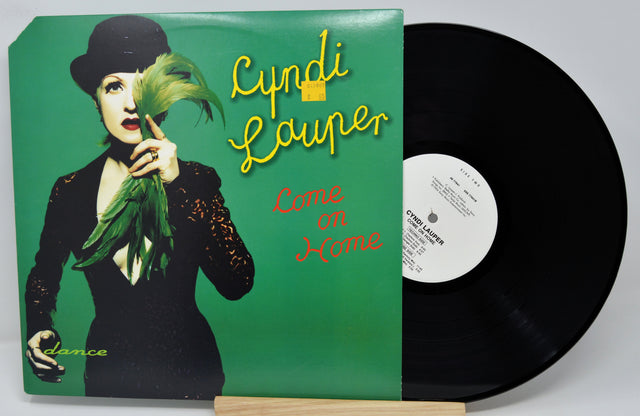 Vinyl record with a green cover featuring a person holding leaves, and the title 'Come on Home' by Cyndi Lauper.