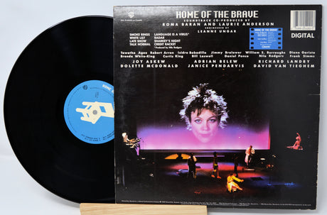 Vinyl record with cover featuring a woman's face and text on a light gray background