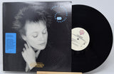 Vinyl record with cover featuring a person's face, on a white background