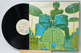 Vinyl record with a colorful cover featuring a drummer and cityscape.
