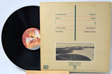 Vinyl record with a matching brown record cover on a light blue background