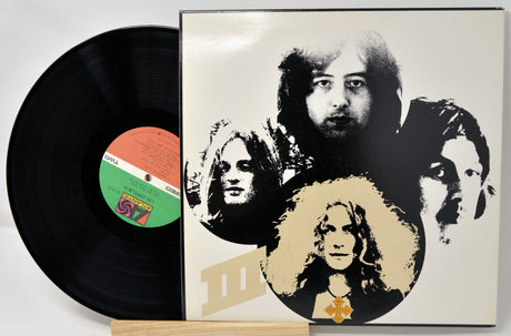 Vinyl record with a cover featuring black and white portraits of band members on a white background.