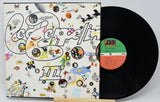 Vinyl record with a colorful cover featuring abstract designs and text.