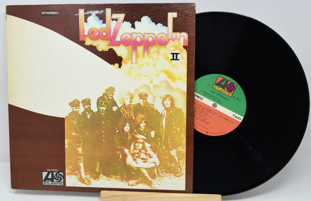 Vinyl record with 'Led Zeppelin II' album cover showing band members.