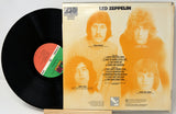 Vinyl record with its cover featuring a band on an orange background