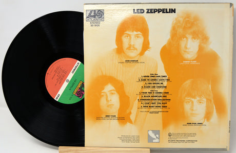 Vinyl record with its cover featuring a band on an orange background