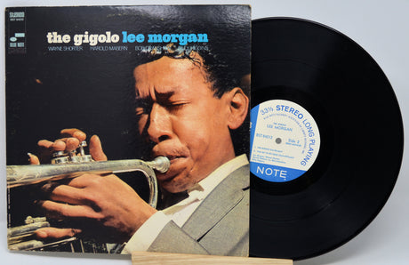 Vinyl record with cover featuring a musician playing a trumpet, on a light gray background.