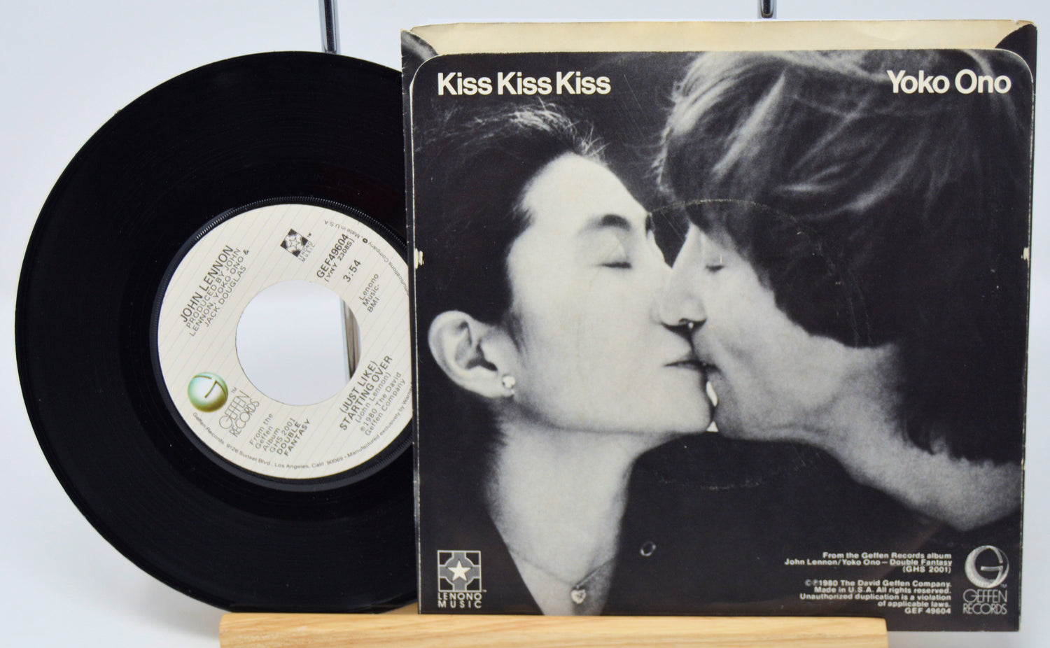 Vinyl record and cover with a black and white image of two people kissing, titled 'Kiss Kiss Kiss' by Yoko Ono.