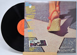 'Leo Kottke 1971-1976' Vinyl record with a colorful cover featuring a person in red shoes and text.