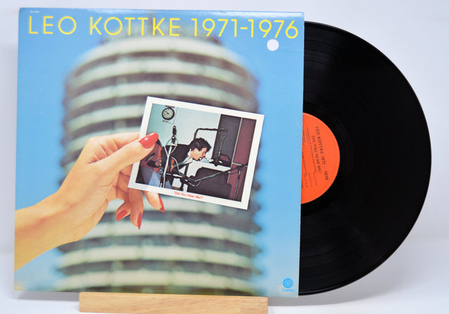 Vinyl record with a photo of a person in a studio and album cover displaying 'Leo Kottke 1971-1976'.