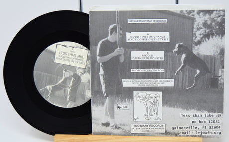 Vinyl record with its cover featuring a black and white photo of two people and a dog.