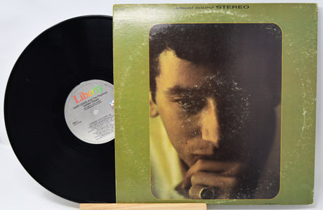 Vinyl record with green cover featuring a close-up of a person's face, on a white background.