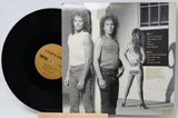 Vinyl record with cover featuring a black and white photo of two people and a woman.