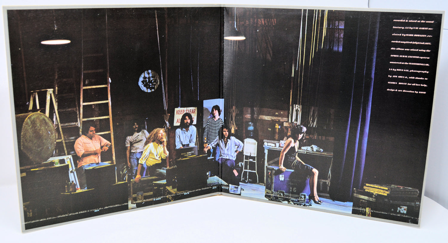 Album cover with multiple images of people in a room on a black background