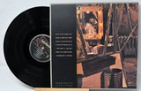 Vinyl record with cover featuring a person in a room with a mirror.