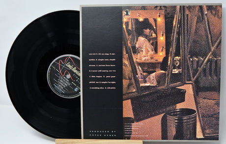 Vinyl record with cover featuring a person in a room with a mirror.