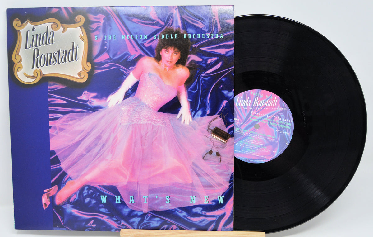 Vinyl record with cover featuring a woman in a pink dress on a blue background