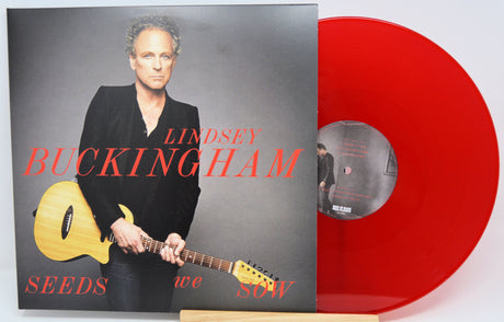 Lindsey Buckingham's 'Seeds We Sow' 12-inch vinyl record shown with its album cover and a translucent red vinyl disc on a white background.