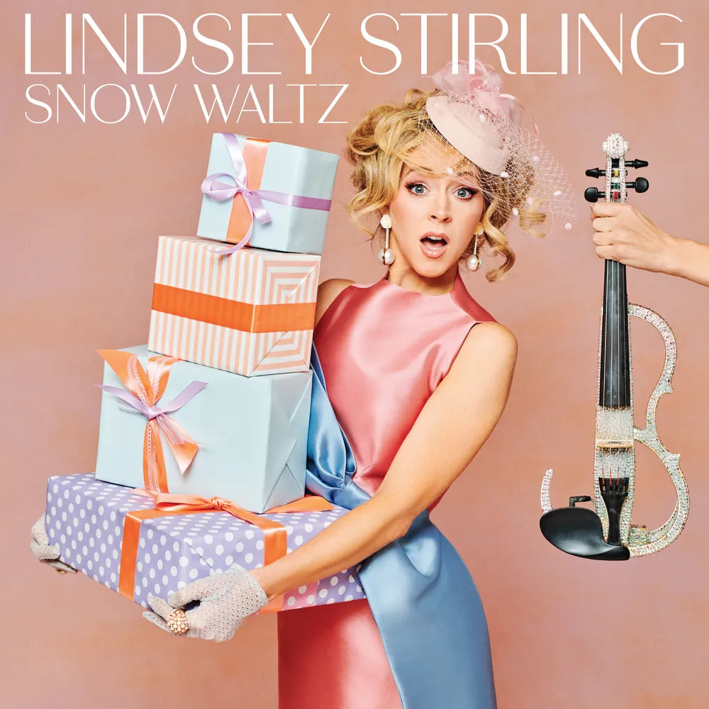 Album cover featuring a woman with gifts and a violin, with 'Lindsey Stirling Snow Waltz' text.