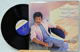 Vinyl record with a cover featuring a person leaning against a wall.