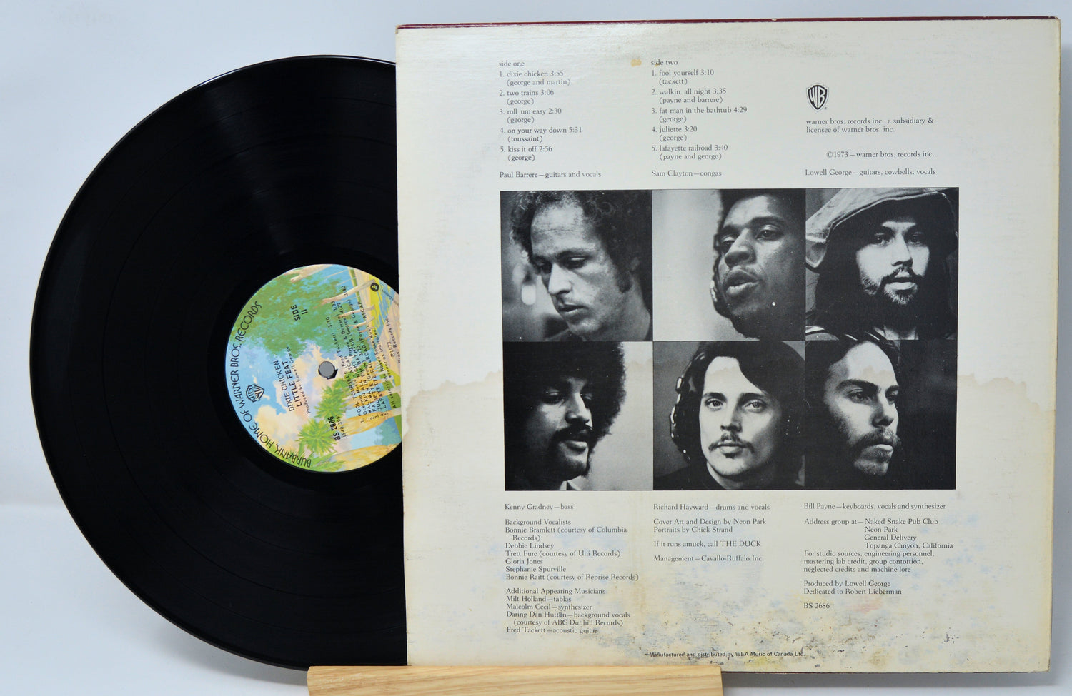 Vinyl record with cover featuring black and white portraits and text on a light gray background