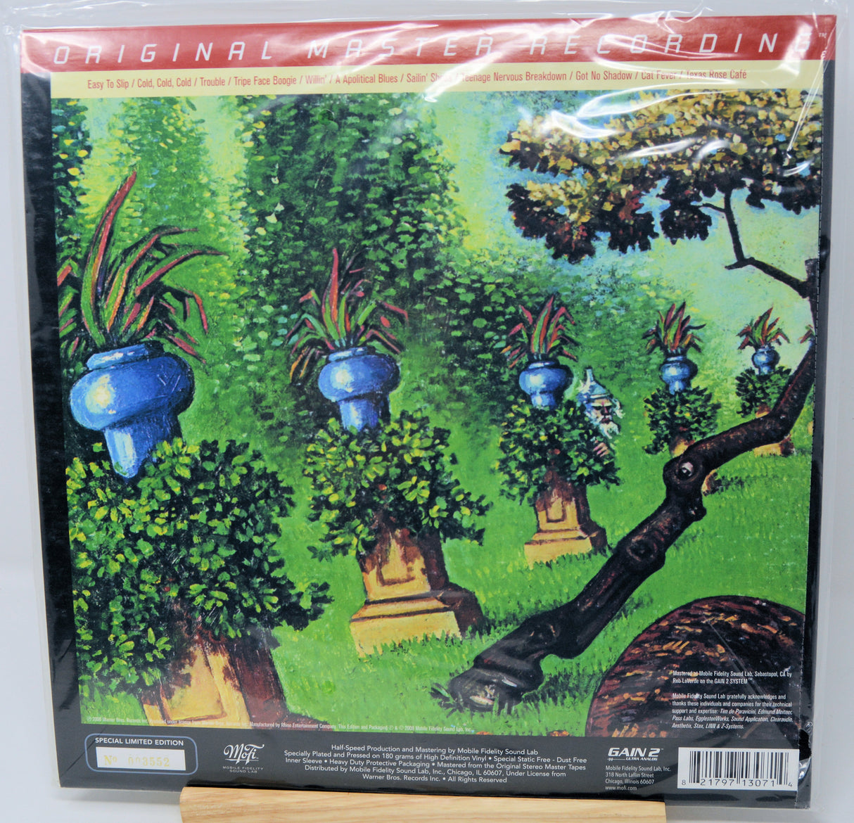 A vinyl record sleeve for Bane's 'Original Master Recording' featuring a colorful painted illustration of a lush green garden with potted plants and a tree trunk in the foreground.