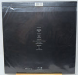 The back cover of a vinyl record in its original shrink wrap, featuring a black background with white track listing text and a barcode at the top.