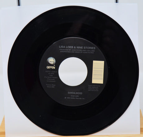 Black vinyl record with a white label on a white background