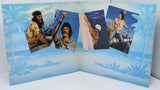 Inside gatefold album cover with four photos of a person on a boat against a blue background.