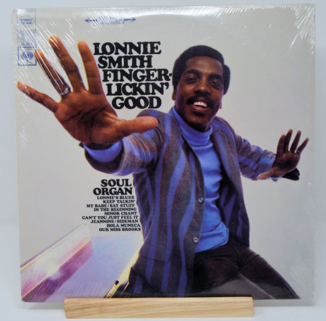 Front cover of Lonnie Smith 'Finger-Lickin' Good' LP featuring Lonnie Smith in vibrant attire reaching forward
