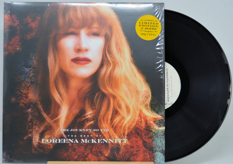 Vinyl record album 'The Journey So Far: The Best of Lorena McKennitt' with the LP partially pulled from the sleeve, showing the black record and cover art featuring a portrait of Lorena McKennitt.