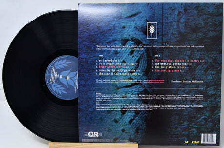 Vinyl record shown with the back of the album cover, featuring a black record partially pulled from the sleeve on a white background.