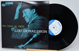 Lou Donaldson's 'The Time Is Right' vinyl record LP with its cover sleeve and the black record partially pulled out, displayed on a light gray background.