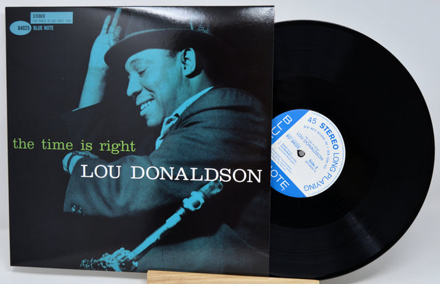 Lou Donaldson's 'The Time Is Right' vinyl record LP with its cover sleeve and the black record partially pulled out, displayed on a light gray background.