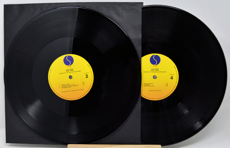Two vinyl records with yellow labels on a white background