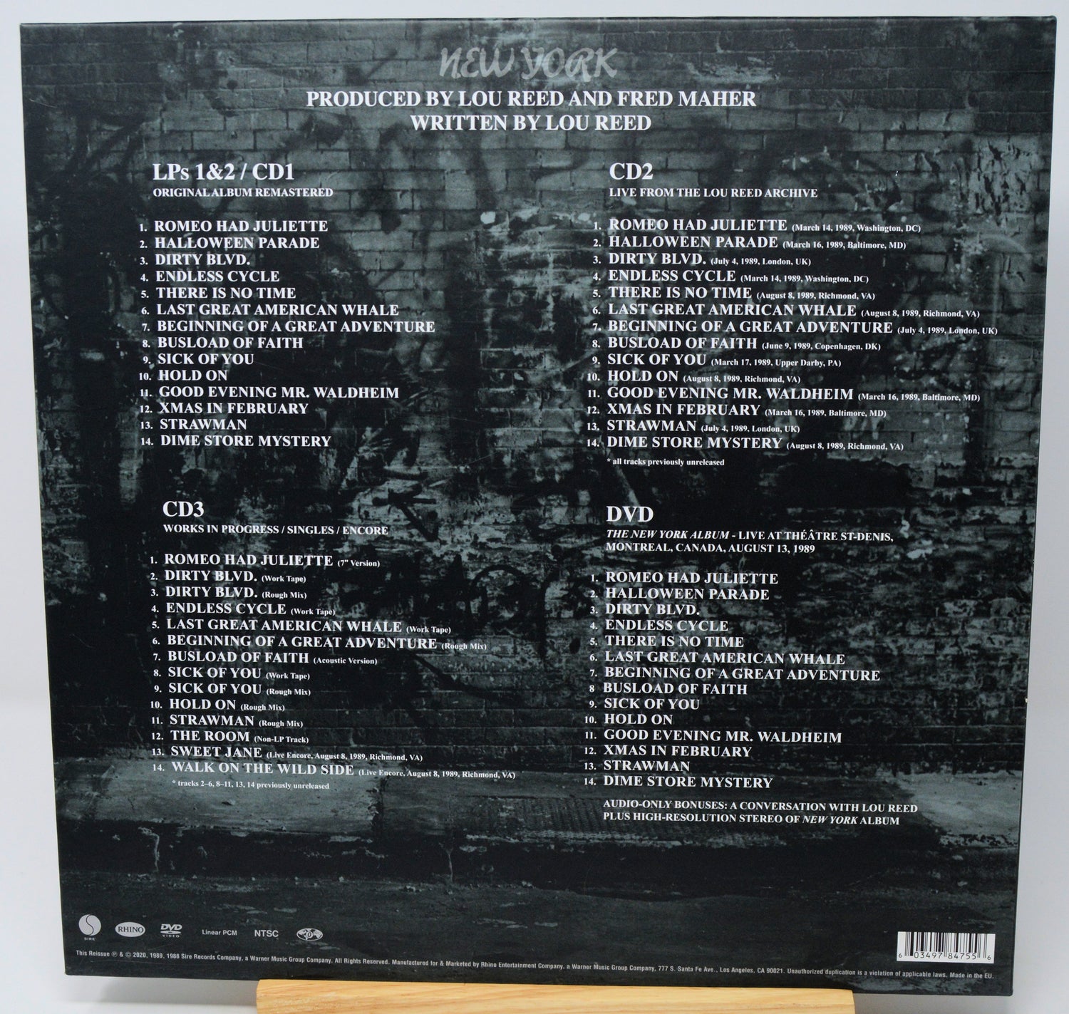 Back cover of a music album with tracklist and production credits on a dark background