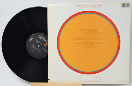 Vinyl record with orange label and white cover on a light gray background