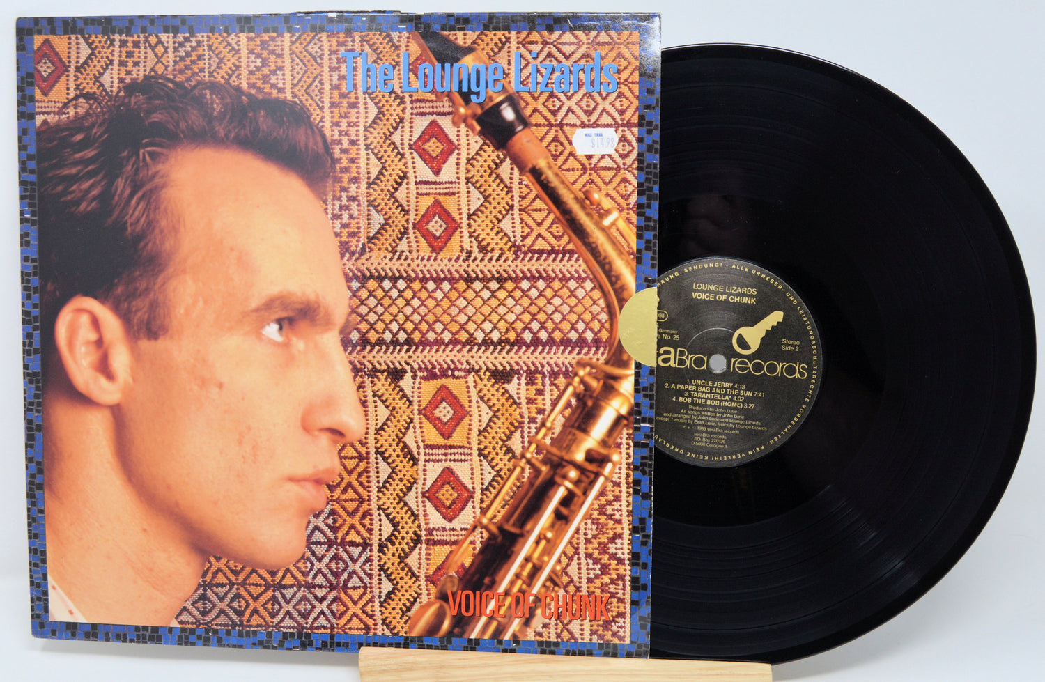 Vinyl record with cover featuring a man's profile and saxophone, on a light blue background.