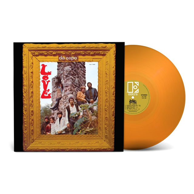 A vinyl record album shown with its outer sleeve and the record disc. The sleeve features a gold ornate frame around the da capo 'Love' cover art, and the vinyl disc is a translucent orange color with a yellow-green center label.