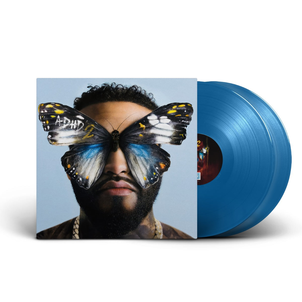 Vinyl record with a butterfly on the cover featuring a person's face, against a blue background.