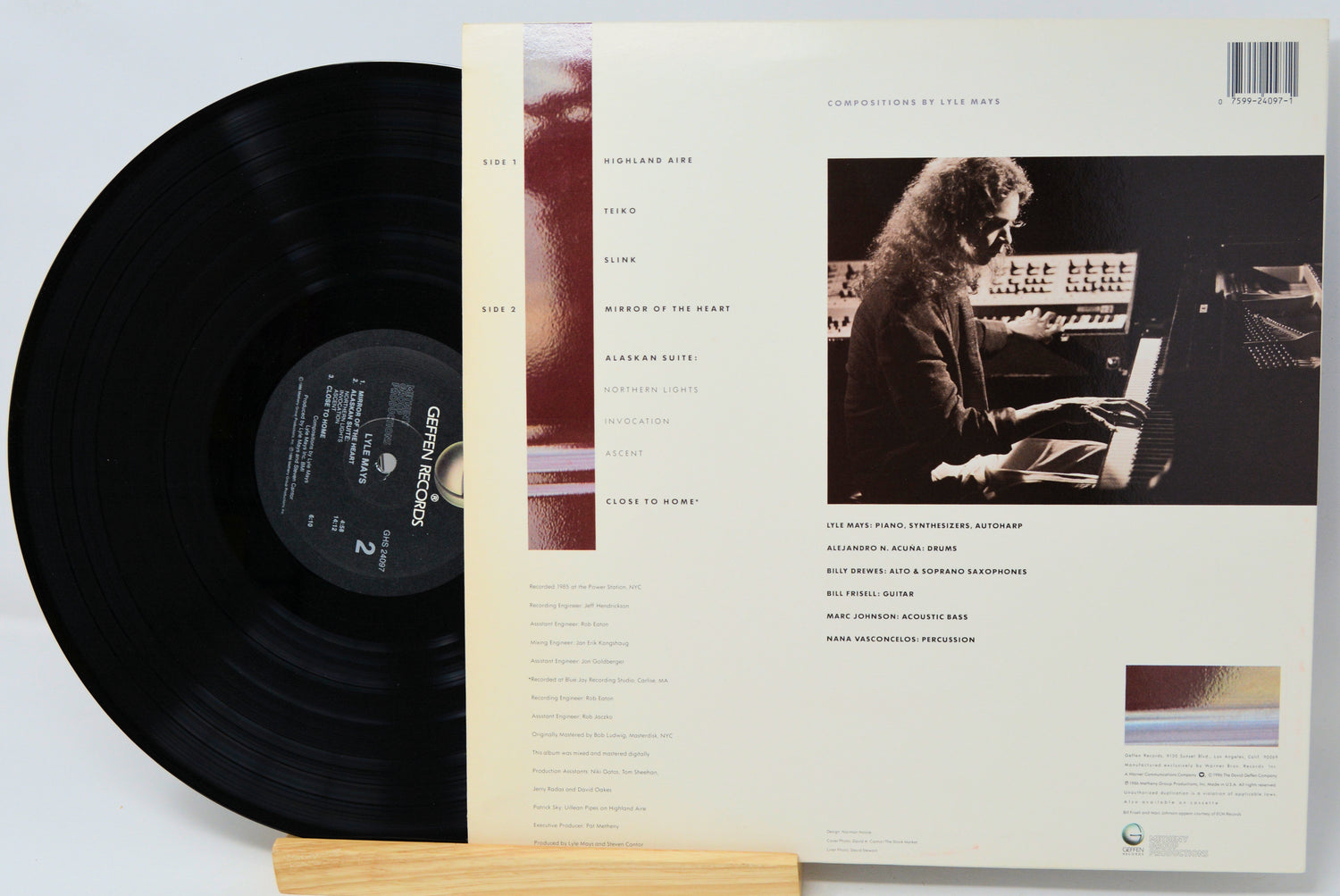 Vinyl record with its cover featuring a person at a keyboard on a light gray background