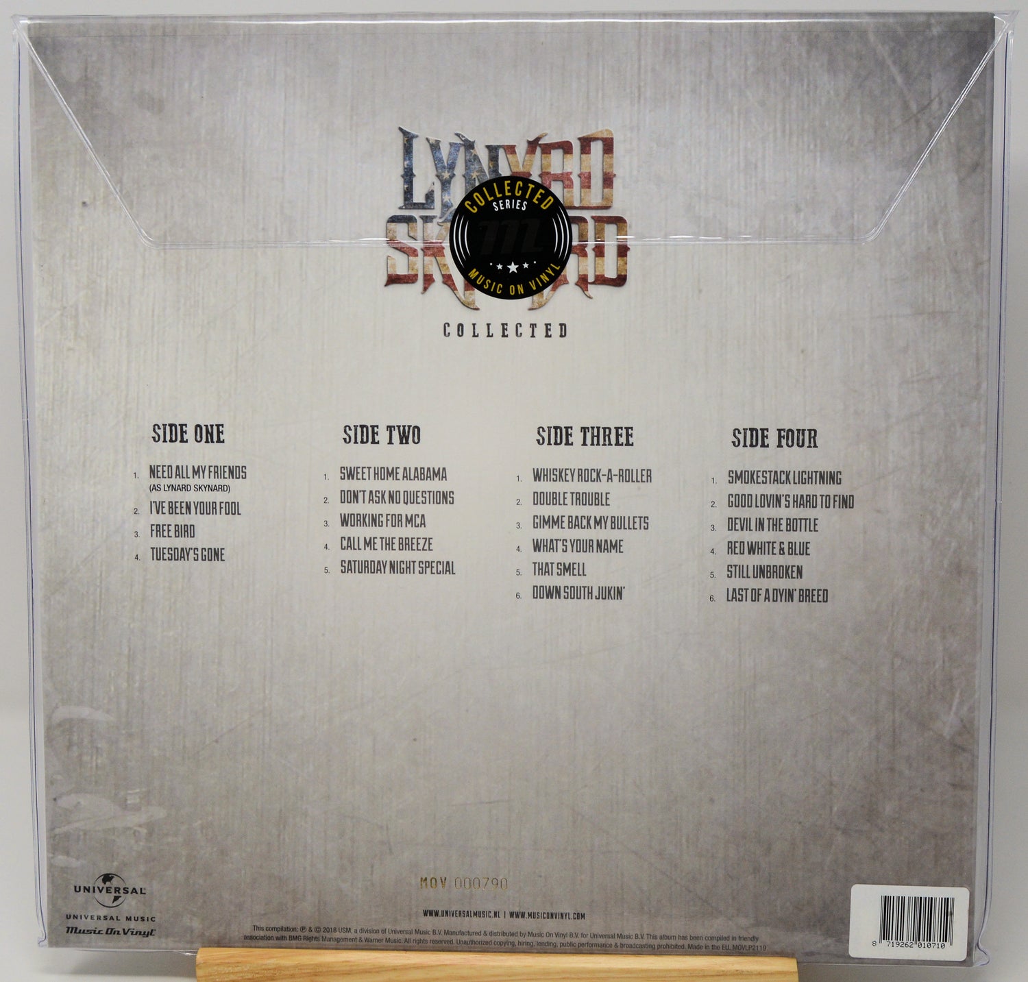 The back cover of a vinyl record sleeve for 'Lyrico Secreto' (Collected), featuring four song lists on a textured silver-gray background with the band's logo at the top.